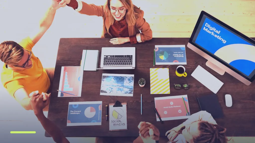 Marketing team around a table with laptops and a screen reading Digital Marketing, planning Google Ads improvements