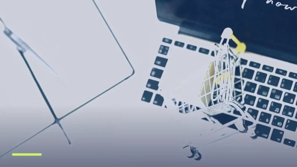 Miniature shopping cart on a laptop keyboard, representing Google Shopping product listing ads