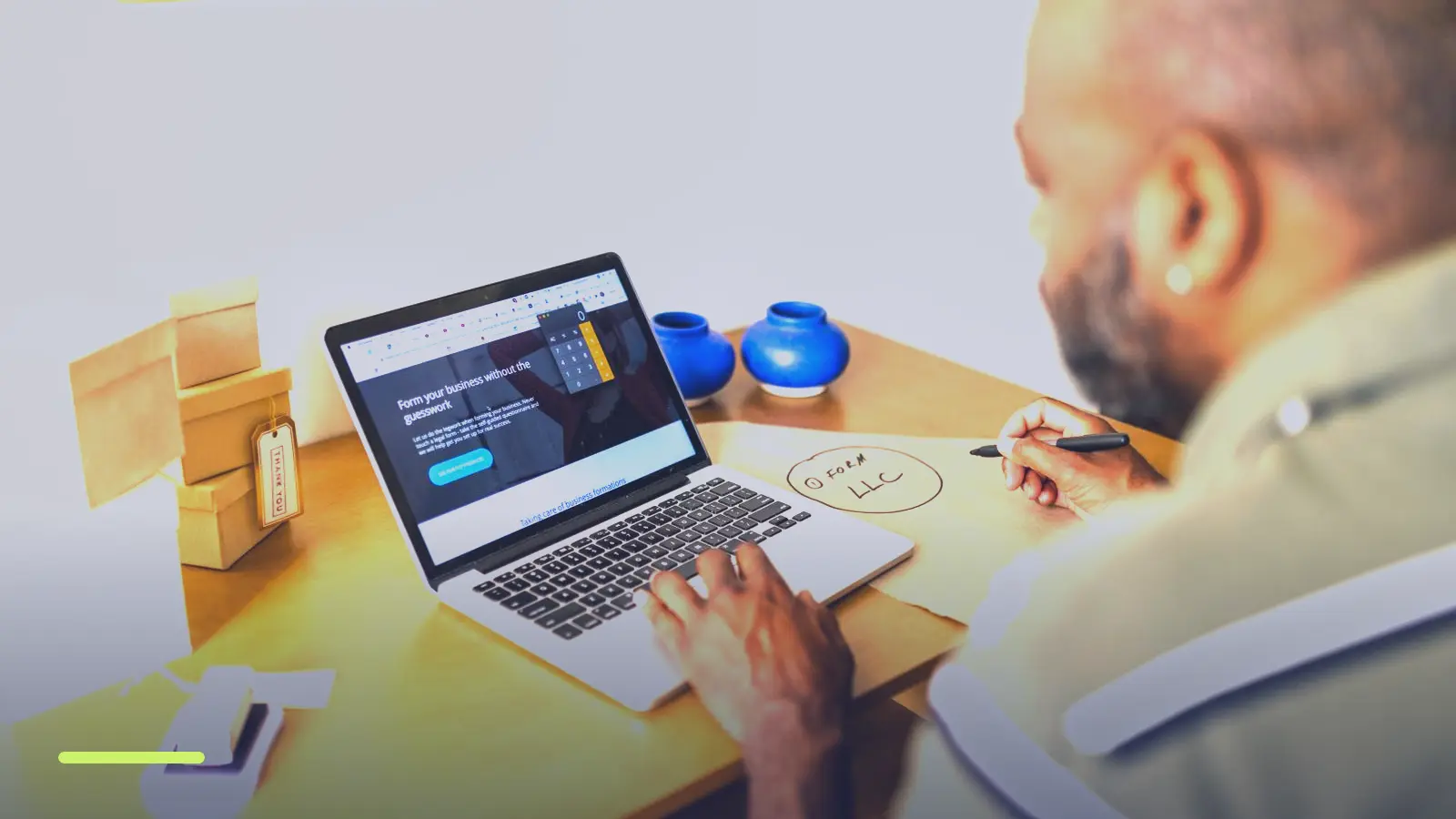 Small business owner working on a laptop beside product boxes, deciding whether Google Ads will work